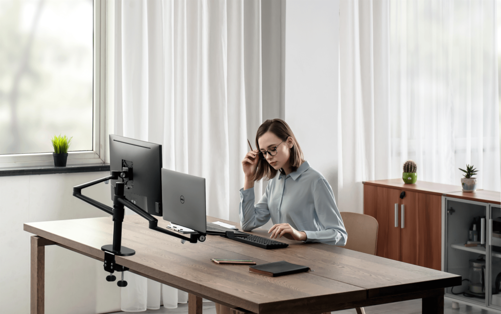 vrouw zittend aan haar ergonomische werkplek